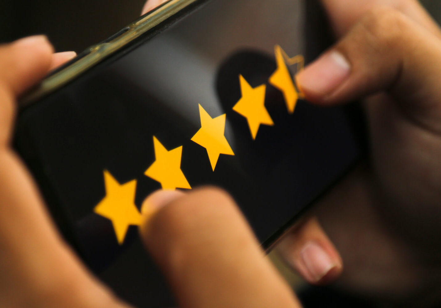 attractive-hands-giving-four-point-five-star-rating-smart-phone